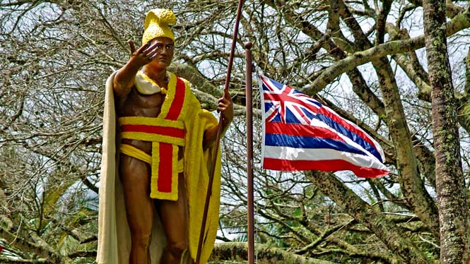 Kamehameha statue next to Hawaiian flag
